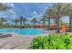 Community pool with a sun deck featuring palm trees and lounge chairs with orange umbrellas at 5031 Serata Dr, Bradenton, FL 34211