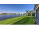 Lush backyard with manicured lawn leading to a tranquil lake and community views at 5209 Barnett Cir, Lakewood Ranch, FL 34211