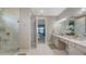 Elegant bathroom showcasing a double sink vanity, marble floors, and a luxurious glass-enclosed shower at 5209 Barnett Cir, Lakewood Ranch, FL 34211