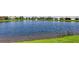 Scenic view of a tranquil lake with a fountain, surrounded by well-maintained landscaping and residences at 5209 Barnett Cir, Lakewood Ranch, FL 34211