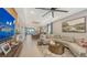 Spacious living room featuring a large sectional sofa, a modern ceiling fan, and an adjacent dining area at 5209 Barnett Cir, Lakewood Ranch, FL 34211