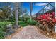 Paver pathway leads to the lanai with lush tropical landscaping and a stone fountain at 5548 Simonton St, Bradenton, FL 34203