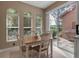 Bright breakfast nook features a wood table, white chairs, three arched windows and a sliding glass door to the patio at 5548 Simonton St, Bradenton, FL 34203