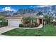 Charming single-story home featuring a well-manicured lawn and vibrant tropical landscaping at 5548 Simonton St, Bradenton, FL 34203