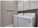 Bright laundry room features a white washer and dryer and white cabinets for storage at 5548 Simonton St, Bradenton, FL 34203