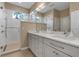 Bright bathroom with dual vanities, a large mirror and a tiled walk-in shower at 5548 Simonton St, Bradenton, FL 34203