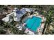 A high angle view of the pool and clubhouse with surrounding palms and lounge seating at 5548 Simonton St, Bradenton, FL 34203