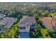Stunning aerial view of home showing lush greenery, mature palms, and a tile roof at 5670 Rock Dove Dr, Sarasota, FL 34241