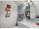 This powder room features soft blue walls, decorative mirror, and a granite vanity countertop at 5670 Rock Dove Dr, Sarasota, FL 34241