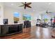 Spacious bonus room featuring hardwood floors, ceiling fans, and large screen TV at 5670 Rock Dove Dr, Sarasota, FL 34241