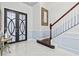 Bright foyer featuring marble floors, decorative staircase, and modern double doors at 5670 Rock Dove Dr, Sarasota, FL 34241