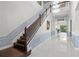 The foyer of this home features a grand staircase, wainscotting, and a view straight through to the back yard at 5670 Rock Dove Dr, Sarasota, FL 34241