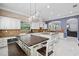 Bright kitchen showcasing white cabinets, a spacious center island, modern lighting, and stainless appliances at 5670 Rock Dove Dr, Sarasota, FL 34241