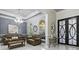 Elegant living room with a decorative chandelier, stylish furniture, and plenty of natural light through arched windows at 5670 Rock Dove Dr, Sarasota, FL 34241