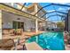The screened-in pool area features ample seating, an outdoor kitchen, and a hot tub for a relaxing outdoor experience at 5670 Rock Dove Dr, Sarasota, FL 34241