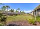 View of the backyard with nice green grass, plants, and trees at 5727 Woodland Sage Dr, Sarasota, FL 34238