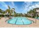 Community swimming pool surrounded by palm trees, lounge chairs, and a covered seating area at 5727 Woodland Sage Dr, Sarasota, FL 34238