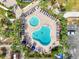 Aerial view of a community pool and lounge area with mature landscaping at 5855 Midnight Pass Rd # 327, Sarasota, FL 34242