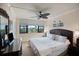 Well-lit bedroom featuring a queen bed, ceiling fan, and dresser at 5855 Midnight Pass Rd # 327, Sarasota, FL 34242