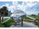 Artistic metal turtle sculpture adds charm to the outdoor space with natural landscaping in a sunny setting at 5855 Midnight Pass Rd # 327, Sarasota, FL 34242