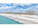 Beautiful beach view with turquoise water and white sand under a blue sky with soft, fluffy clouds at 6140 Midnight Pass Rd # 103, Sarasota, FL 34242