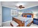 A spacious bedroom offers a ceiling fan and light plus calming blue walls at 6140 Midnight Pass Rd # 103, Sarasota, FL 34242
