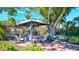 Outdoor gazebo featuring a grill, table and chairs, set amongst tropical landscaping at 6140 Midnight Pass Rd # 103, Sarasota, FL 34242
