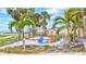 Exterior seating area with colorful chairs surrounded by beautiful tall palm trees with a view of the beach at 6140 Midnight Pass Rd # 103, Sarasota, FL 34242