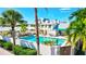 A beautiful pool surrounded by manicured landscaping with palm trees, and lounge chairs for residents at 6140 Midnight Pass Rd # 103, Sarasota, FL 34242