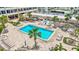 Aerial view of a rectangular community pool, palm trees, and poolside seating at 6140 Midnight Pass Rd # 103, Sarasota, FL 34242