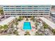 Aerial view of a community pool, hot tub, and lush landscaping for outdoor relaxation at 6140 Midnight Pass Rd # 103, Sarasota, FL 34242