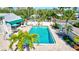 A refreshing community pool with lounge chairs, shade umbrellas, and lush greenery at 6140 Midnight Pass Rd # 103, Sarasota, FL 34242