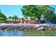 Enjoy waterfront views from this community area with colorful chairs and tropical landscaping at 6140 Midnight Pass Rd # 103, Sarasota, FL 34242
