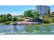 Waterfront community area with lounge chairs, tropical landscaping, and stunning water views at 6140 Midnight Pass Rd # 103, Sarasota, FL 34242