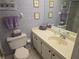 Cozy bathroom featuring patterned wallpaper, vanity, sink, and toilet, creating a functional space at 6142 7Th Ave W # 6142, Bradenton, FL 34209
