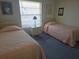 Cozy bedroom features twin beds, a nightstand, and natural light from a window at 6142 7Th Ave W # 6142, Bradenton, FL 34209