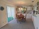 Well-lit dining area featuring a round wooden table, decorative chandelier, and sliding glass doors to the patio at 6142 7Th Ave W # 6142, Bradenton, FL 34209