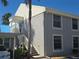 Two-story home featuring gray siding, white trim, and staircase leading to the entrance with a covered carport at 6142 7Th Ave W # 6142, Bradenton, FL 34209