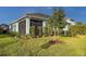 Landscaped backyard with beautiful lawn, mature tree, and screened in patio at 6280 Cassia St, Bradenton, FL 34203