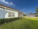 Green backyard with screened lanai and view of the house next door at 6280 Cassia St, Bradenton, FL 34203