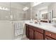 Bathroom with cherry wood cabinetry, large mirror and tiled walk-in shower at 6280 Cassia St, Bradenton, FL 34203