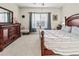 Bright main bedroom with carpet, dark wood furniture, a ceiling fan, and natural light at 6280 Cassia St, Bradenton, FL 34203