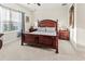 Cozy main bedroom with a wood-frame bed, soft carpet, a ceiling fan, and natural light at 6280 Cassia St, Bradenton, FL 34203