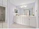 Bathroom featuring double sinks, modern lighting, and a separate glass shower at 7157 Strand Cir # 24-102, Bradenton, FL 34203