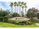 Cypress Strand community entrance sign surrounded by lush landscaping and tall palm trees against a blue sky at 7157 Strand Cir # 24-102, Bradenton, FL 34203
