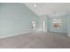 Spacious living room with vaulted ceiling, carpet, and ample natural light from two windows at 7157 Strand Cir # 24-102, Bradenton, FL 34203
