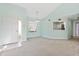 Bright living room with high ceilings, carpet floors, a large window, and open access to the kitchen at 7157 Strand Cir # 24-102, Bradenton, FL 34203