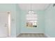 Bright living room with carpet flooring, a modern chandelier, and a window with a view of the outside at 7157 Strand Cir # 24-102, Bradenton, FL 34203