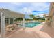 Inviting community pool area with pergola, tables, chairs, and lush greenery, offering a relaxing outdoor retreat at 7157 Strand Cir # 24-102, Bradenton, FL 34203