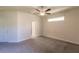 Minimalist bedroom with a ceiling fan, neutral walls and two entry doors at 7354 Helliwell St, North Port, FL 34291